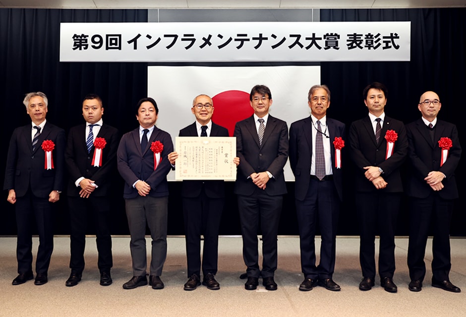 図版：岩城選考委員長と開発関係者による記念撮影