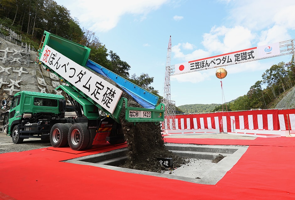 図版:ダンプトラックからCSGが下ろされ礎石が埋納された