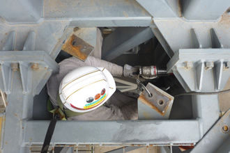 写真：ボックストラス梁内の接合部の解体前にあらかじめボルトを抜き取る作業を行います。
