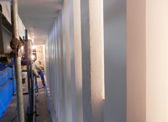 写真：一層壁東面の出格子の漆喰上塗を行っています｡