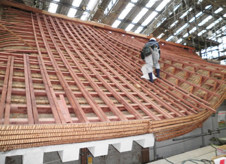 写真：五重屋根の北面部の瓦桟葺きをしているところです。旧来の瓦下地の上に桟を敷いて瓦を葺いていきます。 