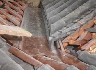写真：三重屋根と比翼入母屋破風（ひよくいりもやはふ）との取合部での谷樋で､昭和大改修時に布設された既存の銅製谷樋に､新規に加工された銅製谷樋を接合しているところです｡ 