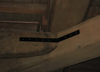 写真：2階床面の火打梁接合部分に取り付けた耐震補強金物です｡